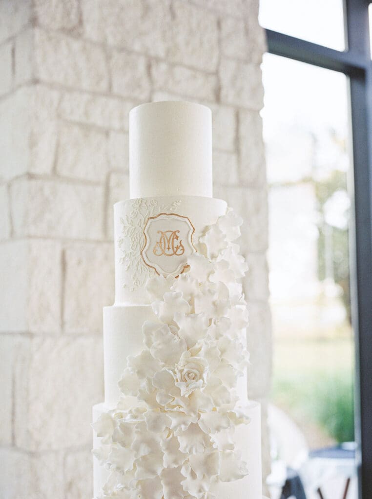 Lush black tie wedding reception at Omni Barton Creek with classic white florals and candlelit tables