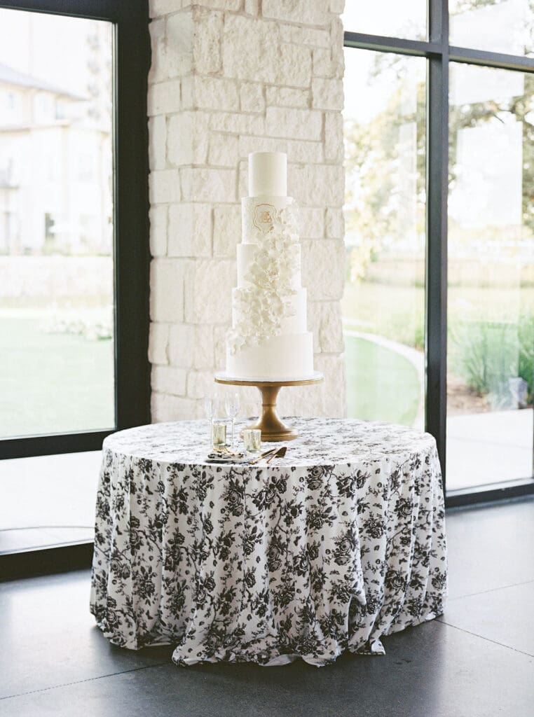 Lush black tie wedding reception at Omni Barton Creek with classic white florals and candlelit tables
