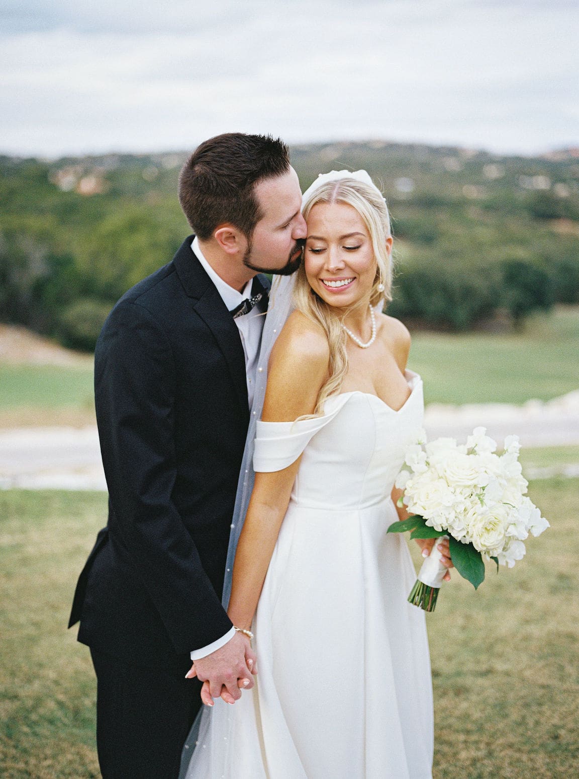 Elegant outdoor ceremony at Omni Barton Creek with white floral arrangements and Hill Country views
