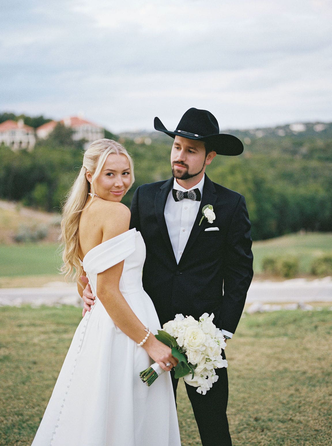 Elegant outdoor ceremony at Omni Barton Creek with white floral arrangements and Hill Country views