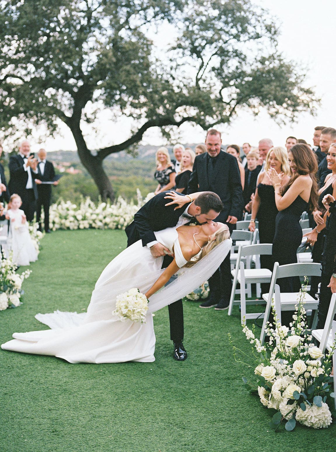 Elegant outdoor ceremony at Omni Barton Creek with white floral arrangements and Hill Country views