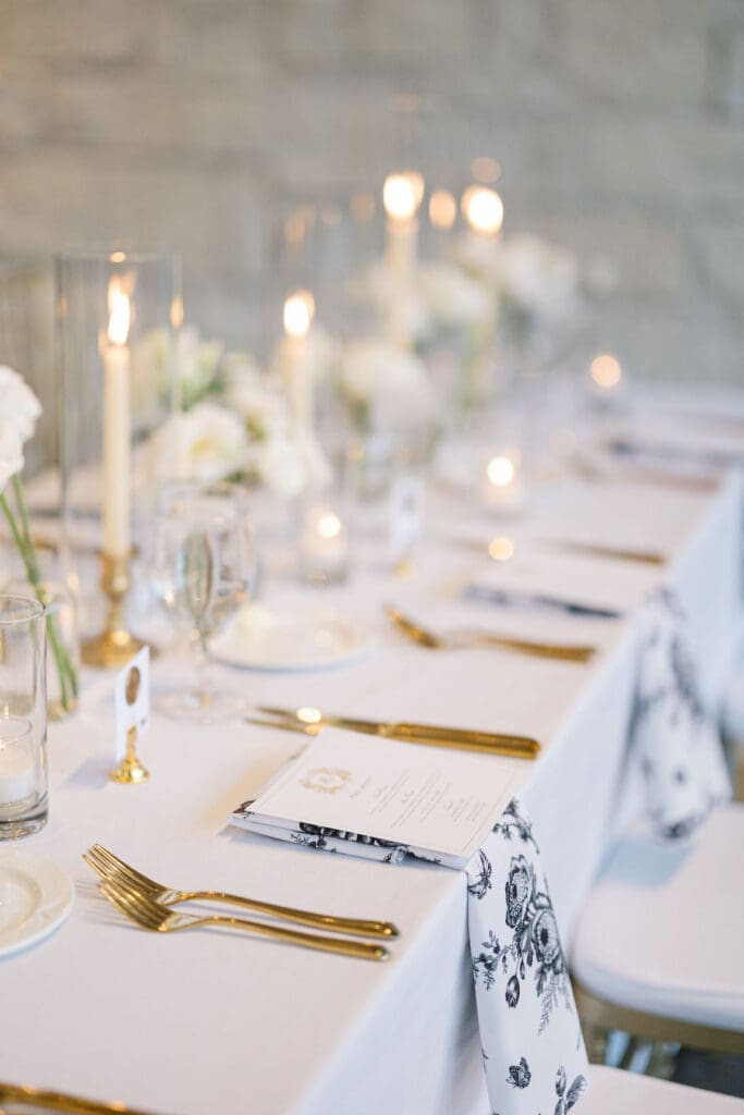 Lush black tie wedding reception at Omni Barton Creek with classic white florals and candlelit tables