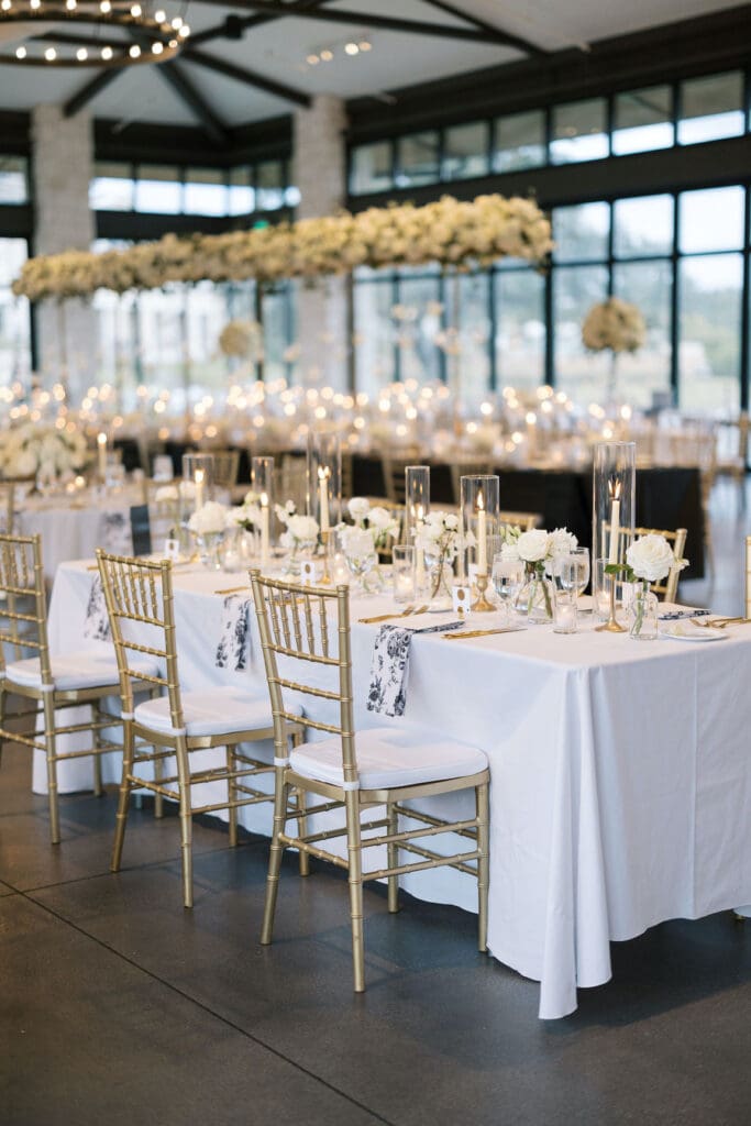 Lush black tie wedding reception at Omni Barton Creek with classic white florals and candlelit tables