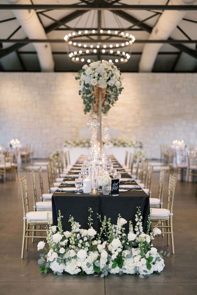 Lush black tie wedding reception at Omni Barton Creek with classic white florals and candlelit tables