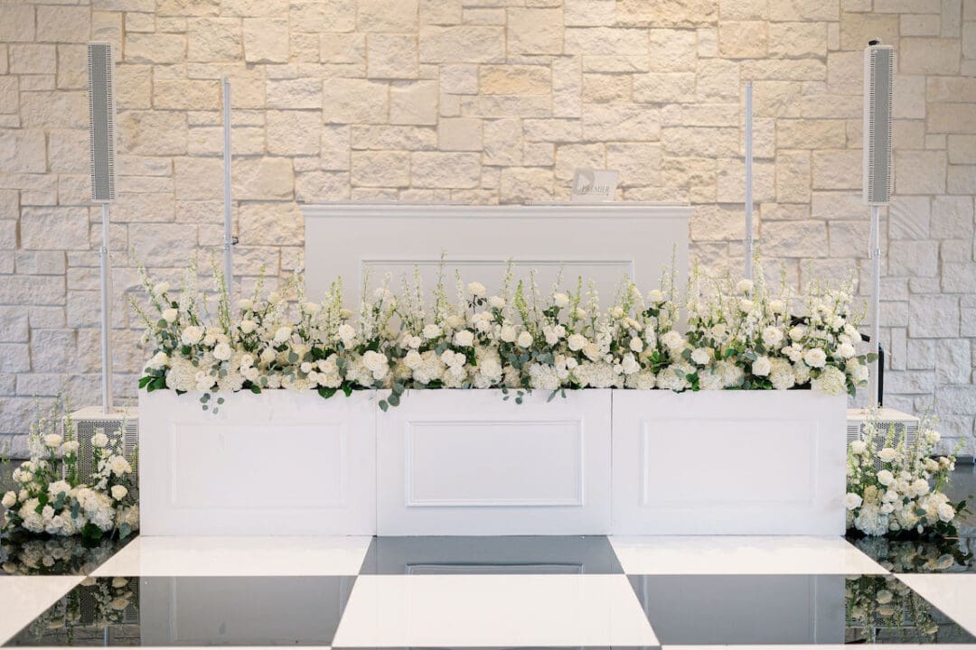 Lush black tie wedding reception at Omni Barton Creek with classic white florals and candlelit tables