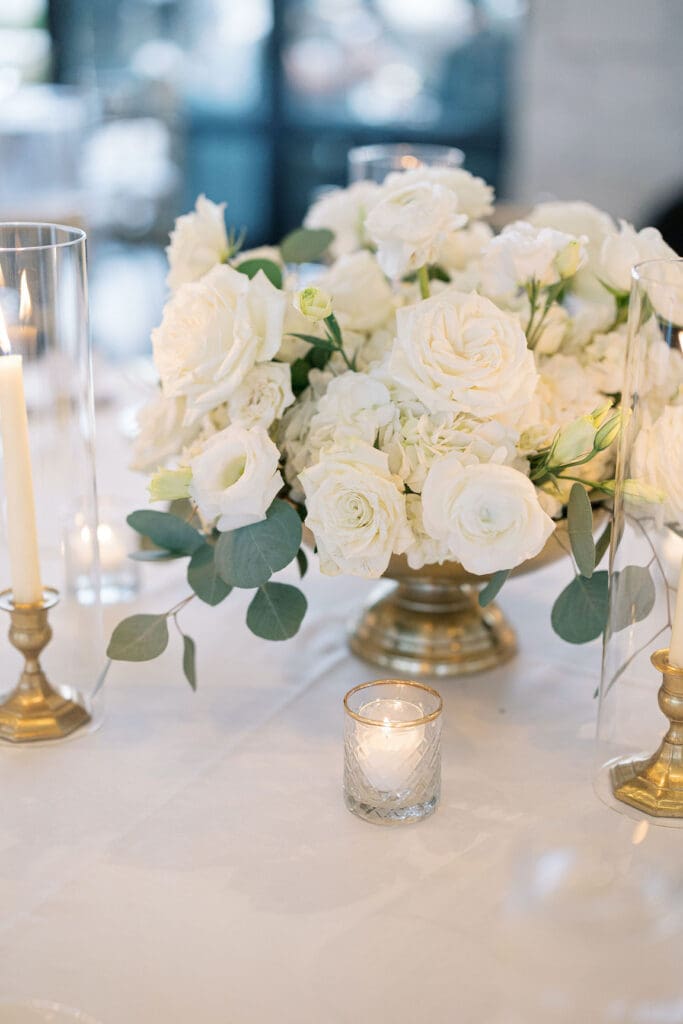 Lush black tie wedding reception at Omni Barton Creek with classic white florals and candlelit tables