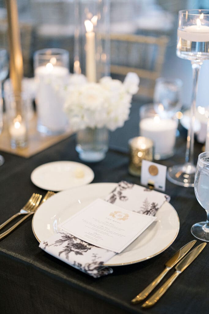Lush black tie wedding reception at Omni Barton Creek with classic white florals and candlelit tables