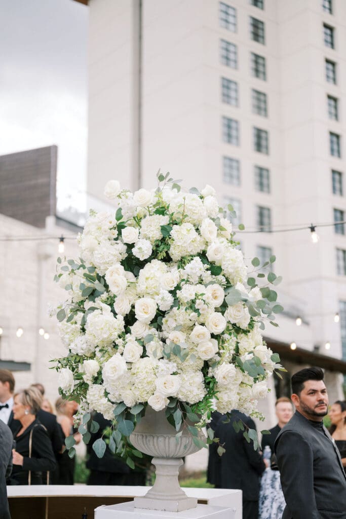 Lush black tie wedding reception at Omni Barton Creek with classic white florals and candlelit tables