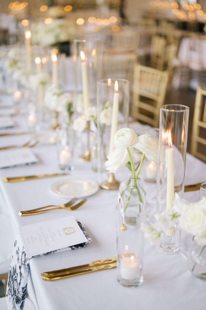 Lush black tie wedding reception at Omni Barton Creek with classic white florals and candlelit tables