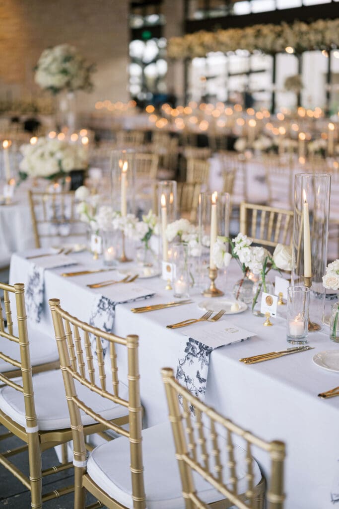 Lush black tie wedding reception at Omni Barton Creek with classic white florals and candlelit tables