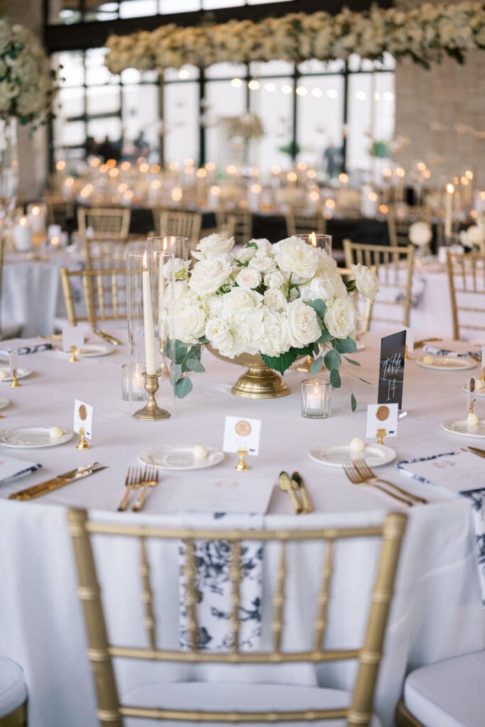 Lush black tie wedding reception at Omni Barton Creek with classic white florals and candlelit tables