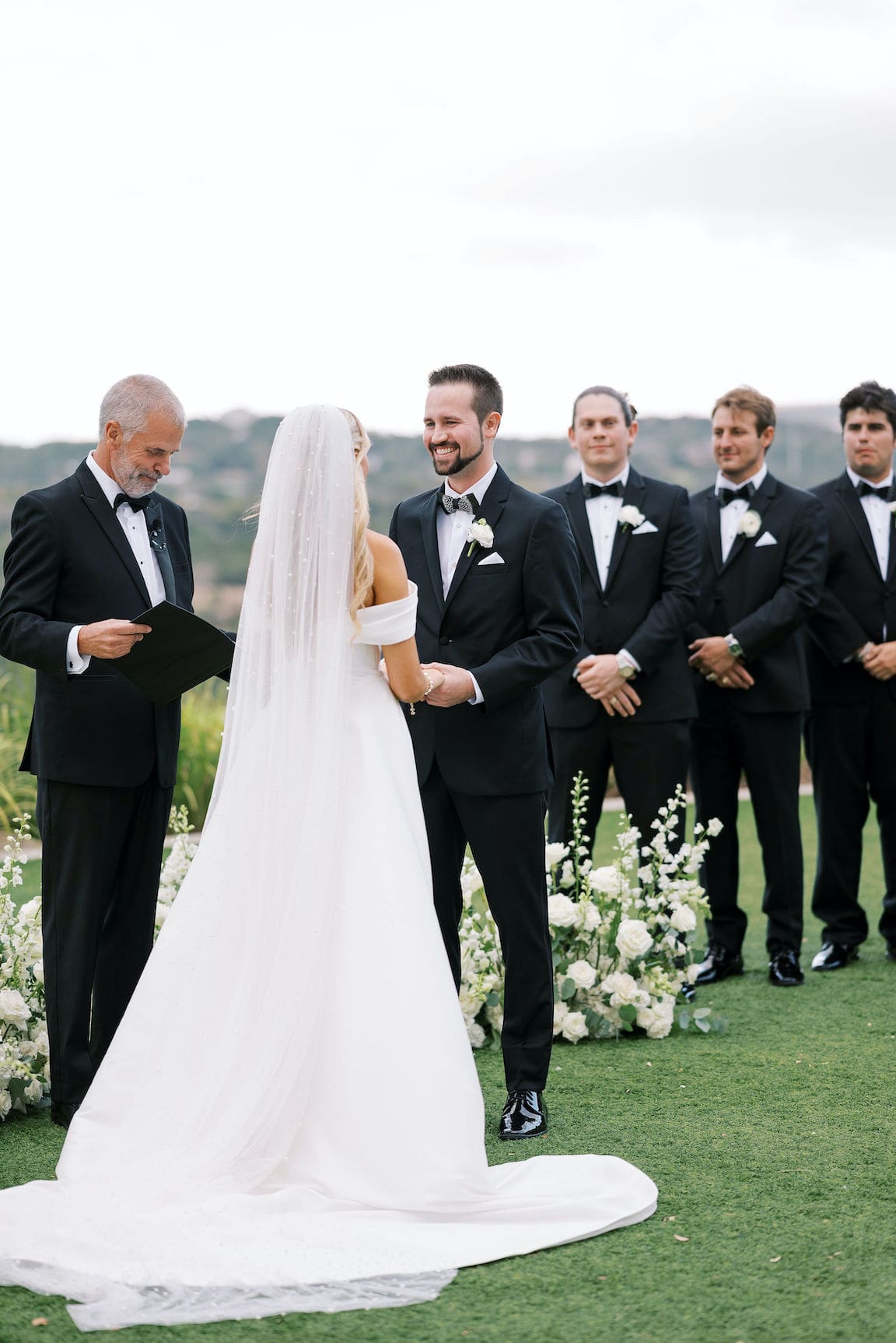 Elegant outdoor ceremony at Omni Barton Creek with white floral arrangements and Hill Country views