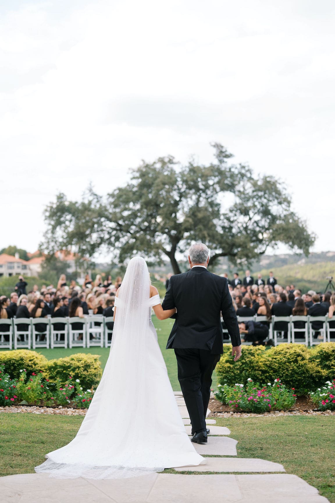 Elegant outdoor ceremony at Omni Barton Creek with white floral arrangements and Hill Country views