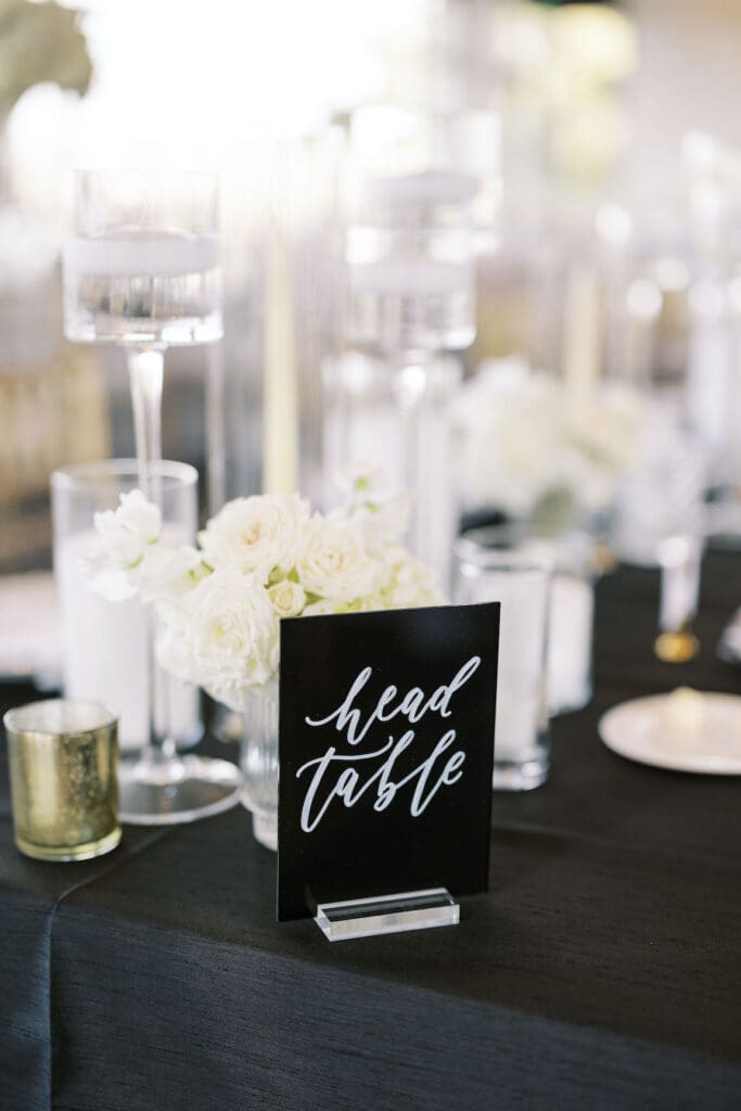Lush black tie wedding reception at Omni Barton Creek with classic white florals and candlelit tables