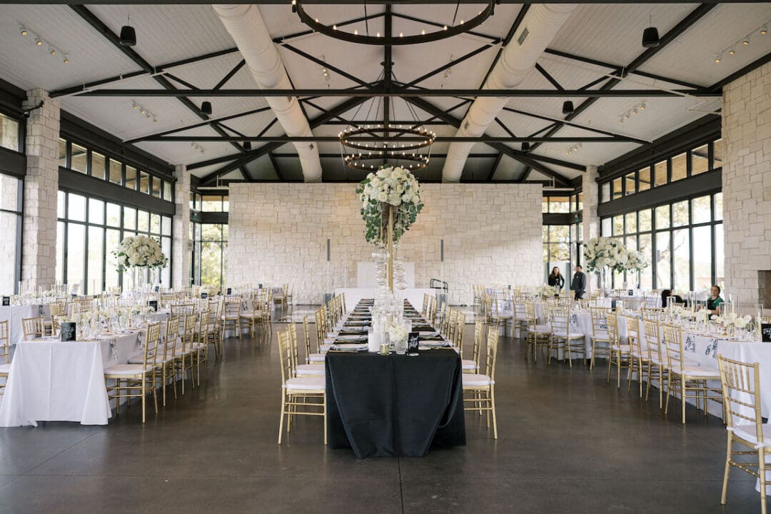 Lush black tie wedding reception at Omni Barton Creek with classic white florals and candlelit tables